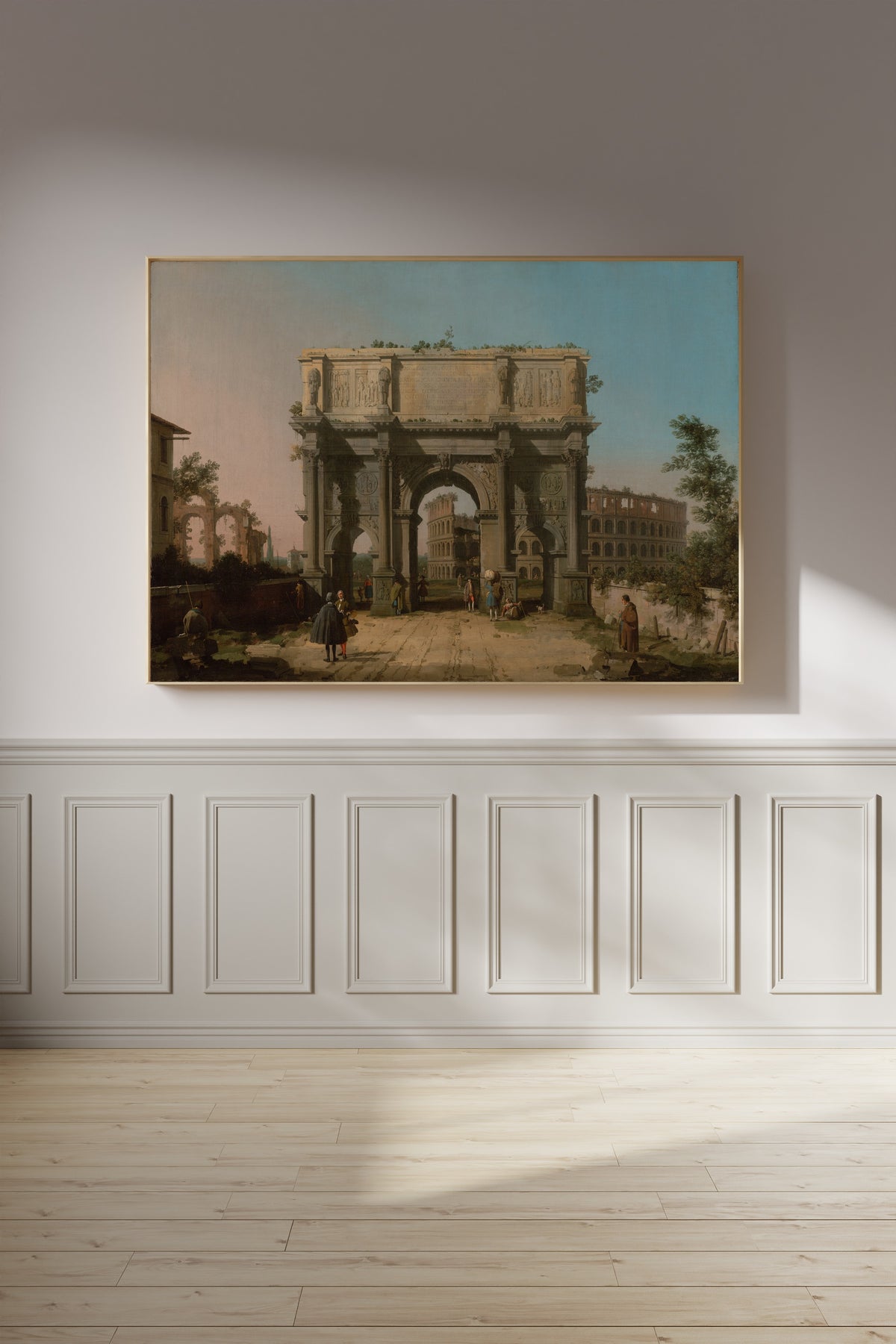 Framed art print of View of the Arch of Constantine with the Colosseum by Canaletto, on a panelled wall in afternoon light
