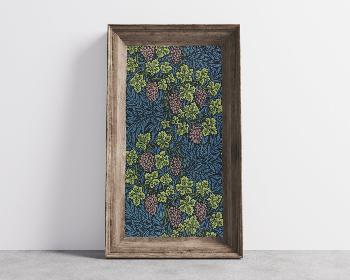 Framed art print of Vine (Blue) by William Morris, in a wide wooden frame leaning against a concrete wall