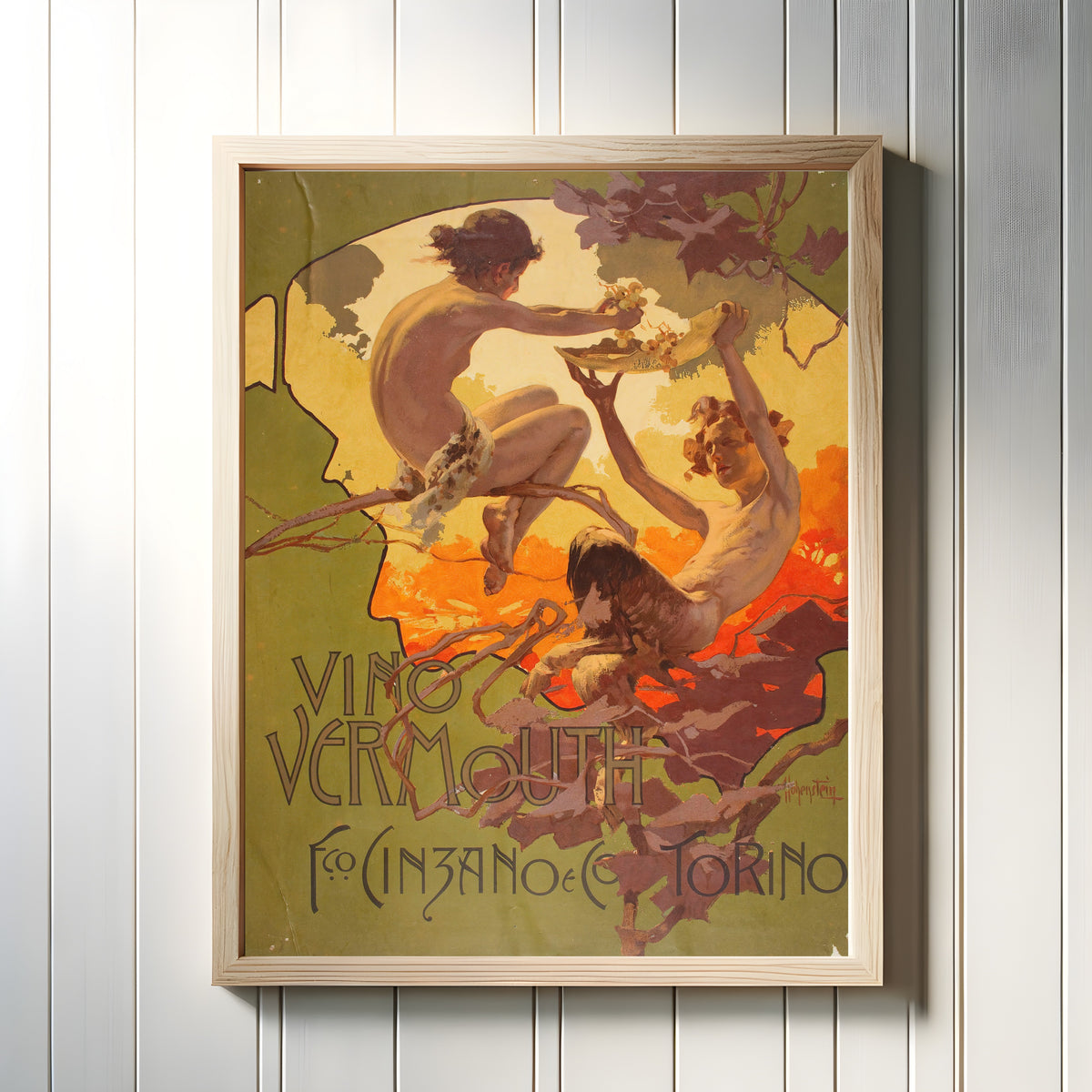 Framed art print of Vino Vermouth Fco. Cinzano e C.º by Adolfo Hohenstein, in a light wood frame on a white panelled wall
