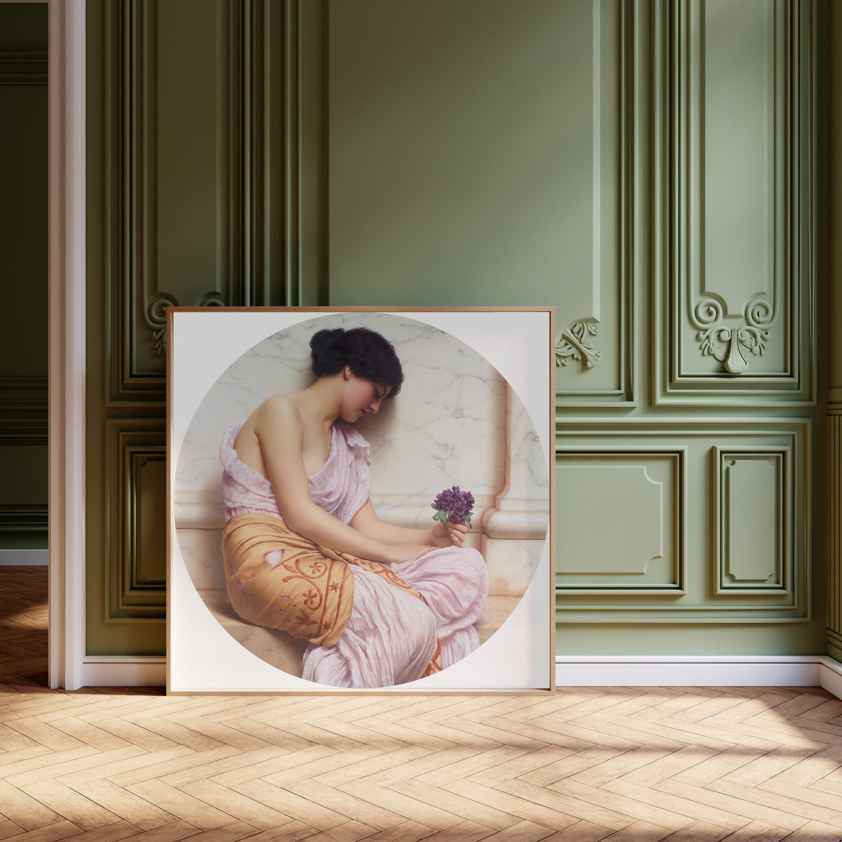 Framed art print of Violets, Sweet Violets by John William Godward, leaning against olive-green panelling on a herringbone floor