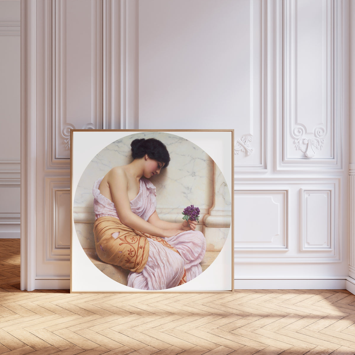 Framed art print of Violets, Sweet Violets by John William Godward, leaning against pale pink panelling on a herringbone floor