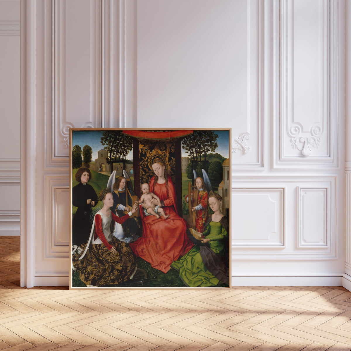 Framed art print of Virgin and Child with Saints Catherine of Alexandria and Barbara by Hans Memling, leaning against pale pink panelling on a herringbone floor