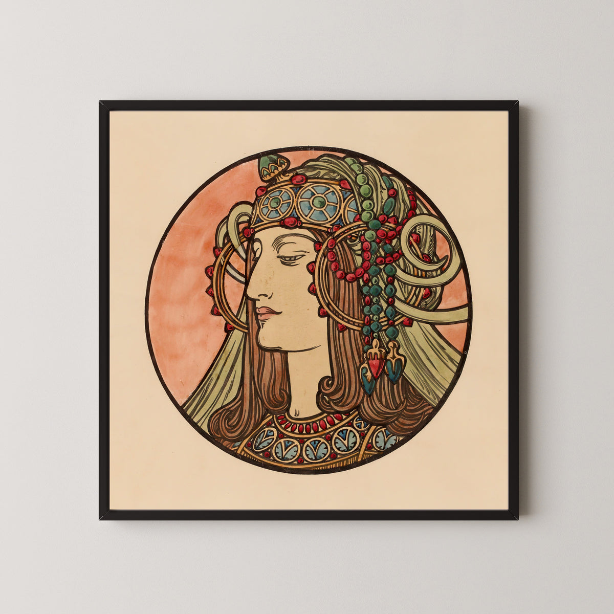 Framed art print of Vitrail pour la façade de la boutique Fouquet (jewelled headdress) by Alphonse Mucha, in a black frame on a pale wall