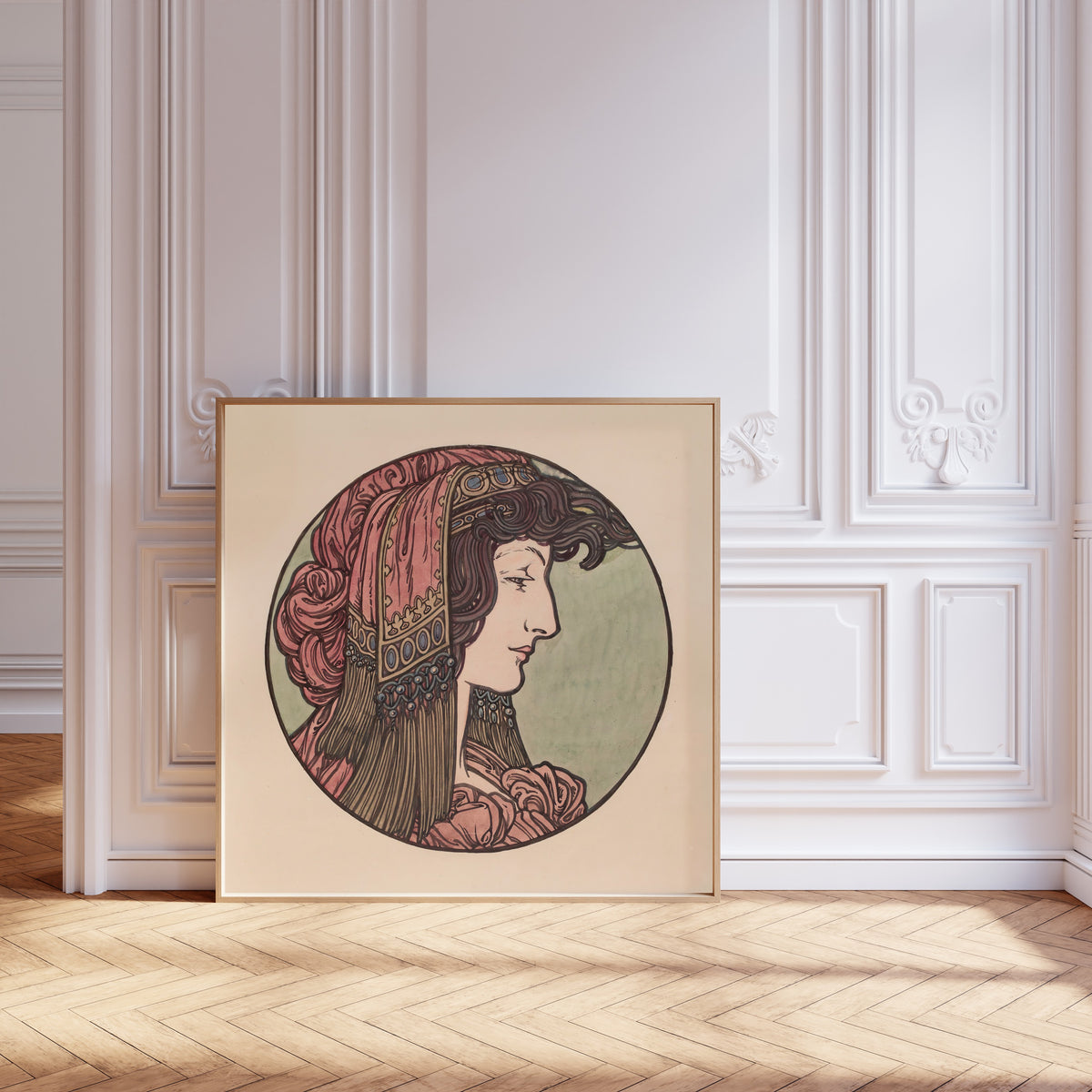 Framed art print of Vitrail pour la façade de la boutique Fouquet (pink headcloth) by Alphonse Mucha, leaning against pale pink panelling on a herringbone floor
