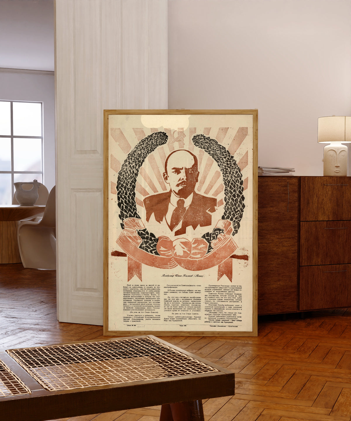 Framed art print of Vladimir Ilyich Ulyanov (Lenin), in a light wood frame leaning in a warm room with a parquet floor