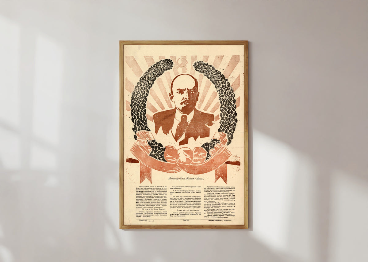 Framed art print of Vladimir Ilyich Ulyanov (Lenin), in a light wood frame on a sunlit white wall