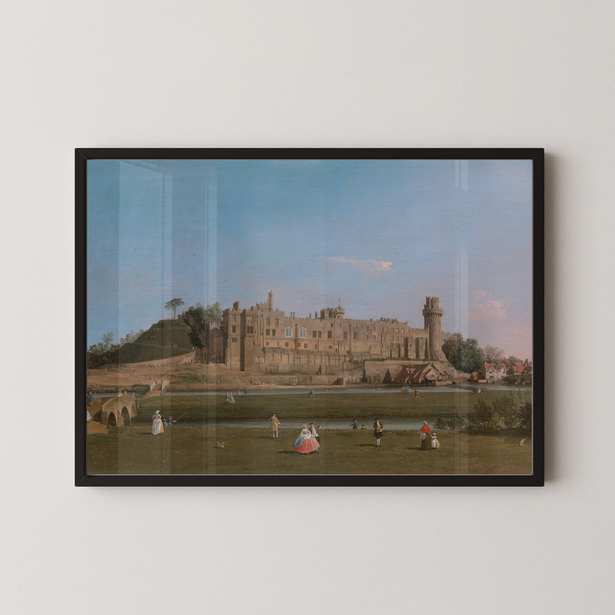 Framed art print of Warwick Castle by Canaletto, in a black frame on a pale wall
