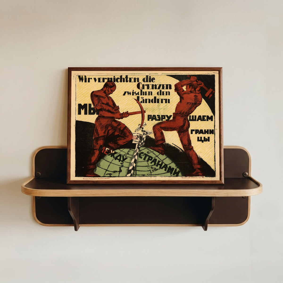 Framed art print of We are destroying the borders between countries, in a dark wood frame resting on a wall shelf