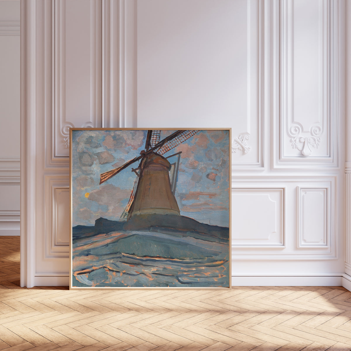 Framed art print of Windmill by Piet Mondrian, leaning against pale pink panelling on a herringbone floor