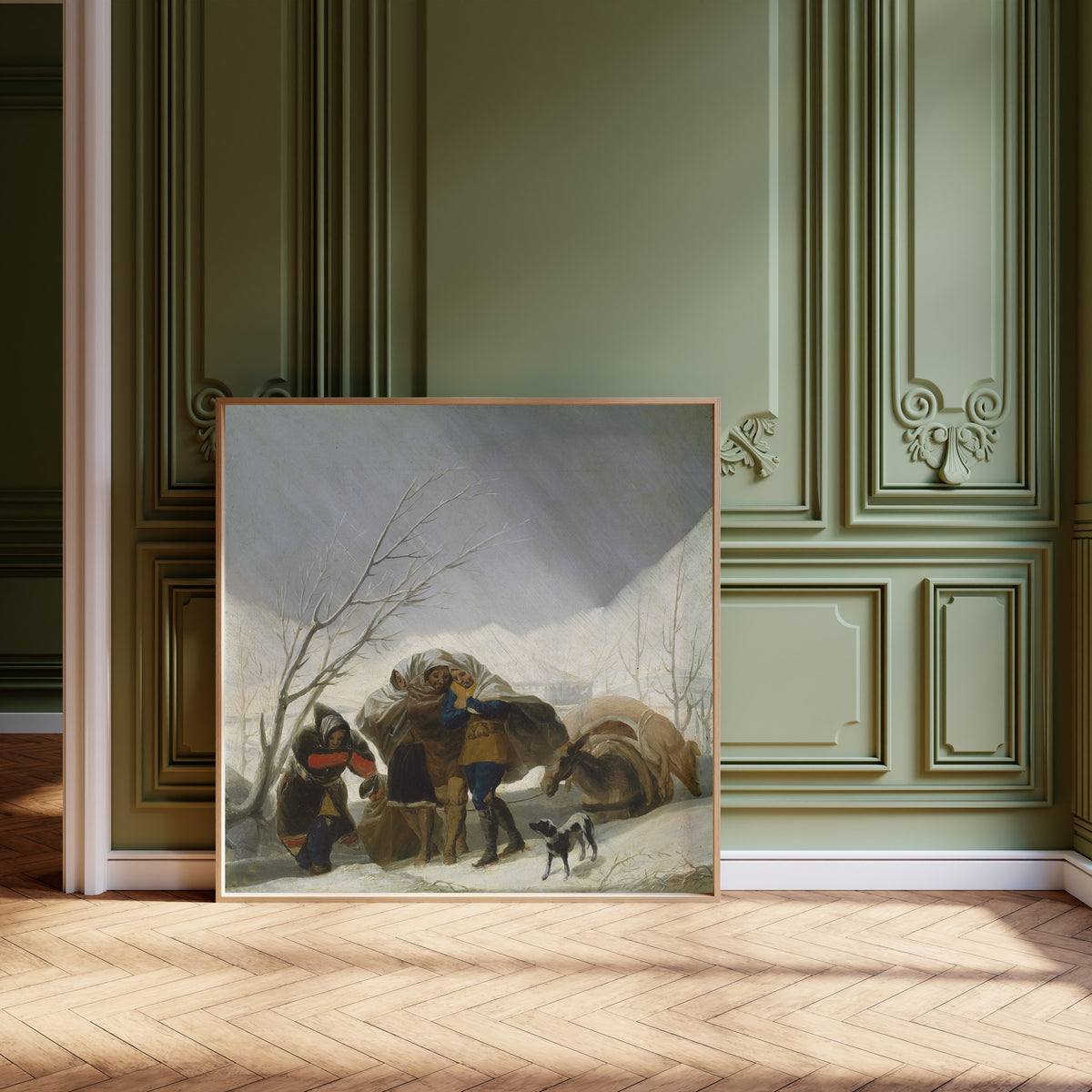 Framed art print of Winter Scene by Francisco de Goya, leaning against olive-green panelling on a herringbone floor
