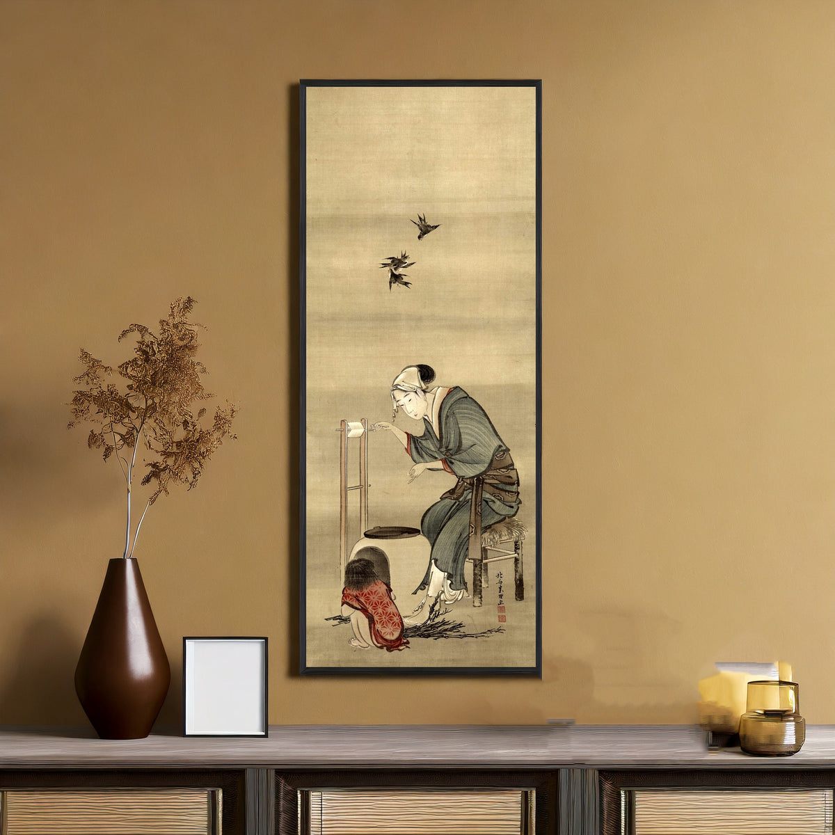 Framed art print of Woman Spinning Silk by Katsushika Hokusai, on an ochre wall above a console table