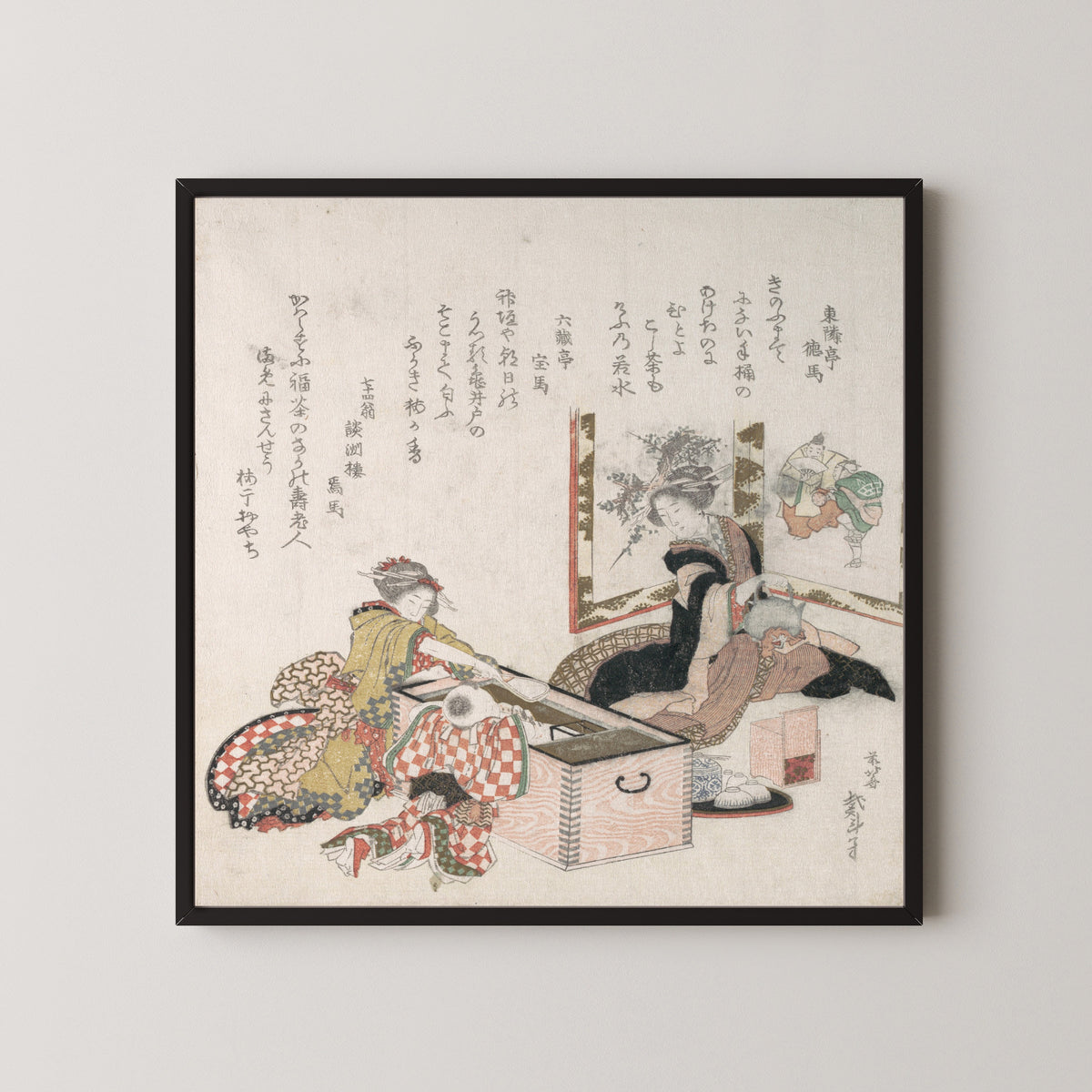 Framed art print of Women Preparing Tea Around the Fire-Holder by Katsushika Hokusai, in a black frame on a pale wall