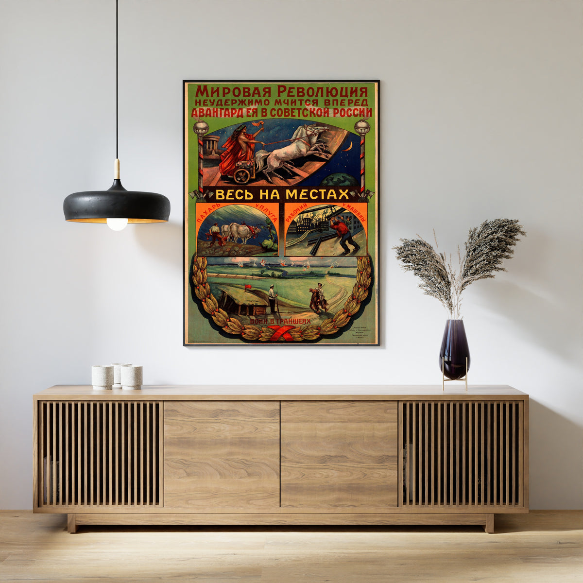Framed art print of World Revolution Rushes Irresistibly Forward, above a slatted wood sideboard