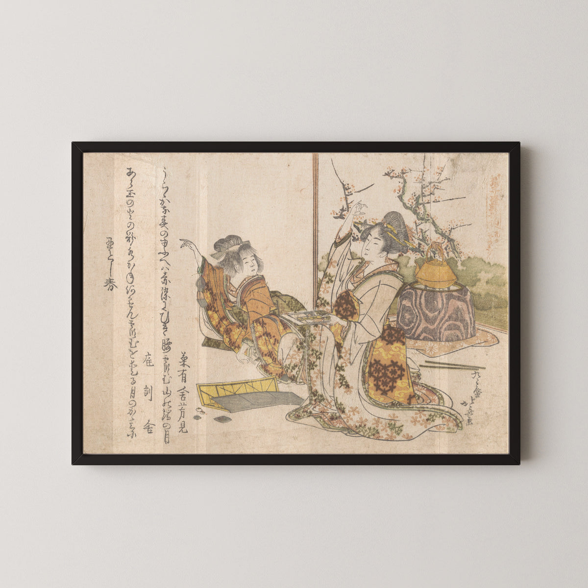 Framed art print of Young Woman and Little Girl Playing Musashi by Katsushika Hokusai, in a black frame on a pale wall