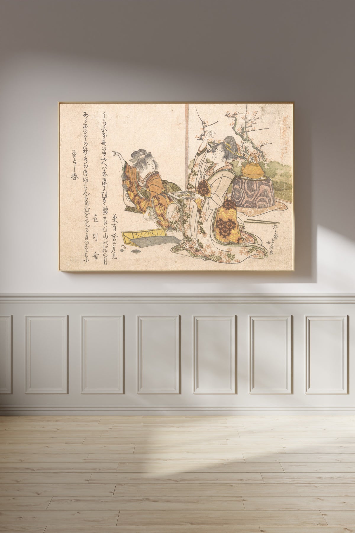 Framed art print of Young Woman and Little Girl Playing Musashi by Katsushika Hokusai, on a panelled wall in afternoon light