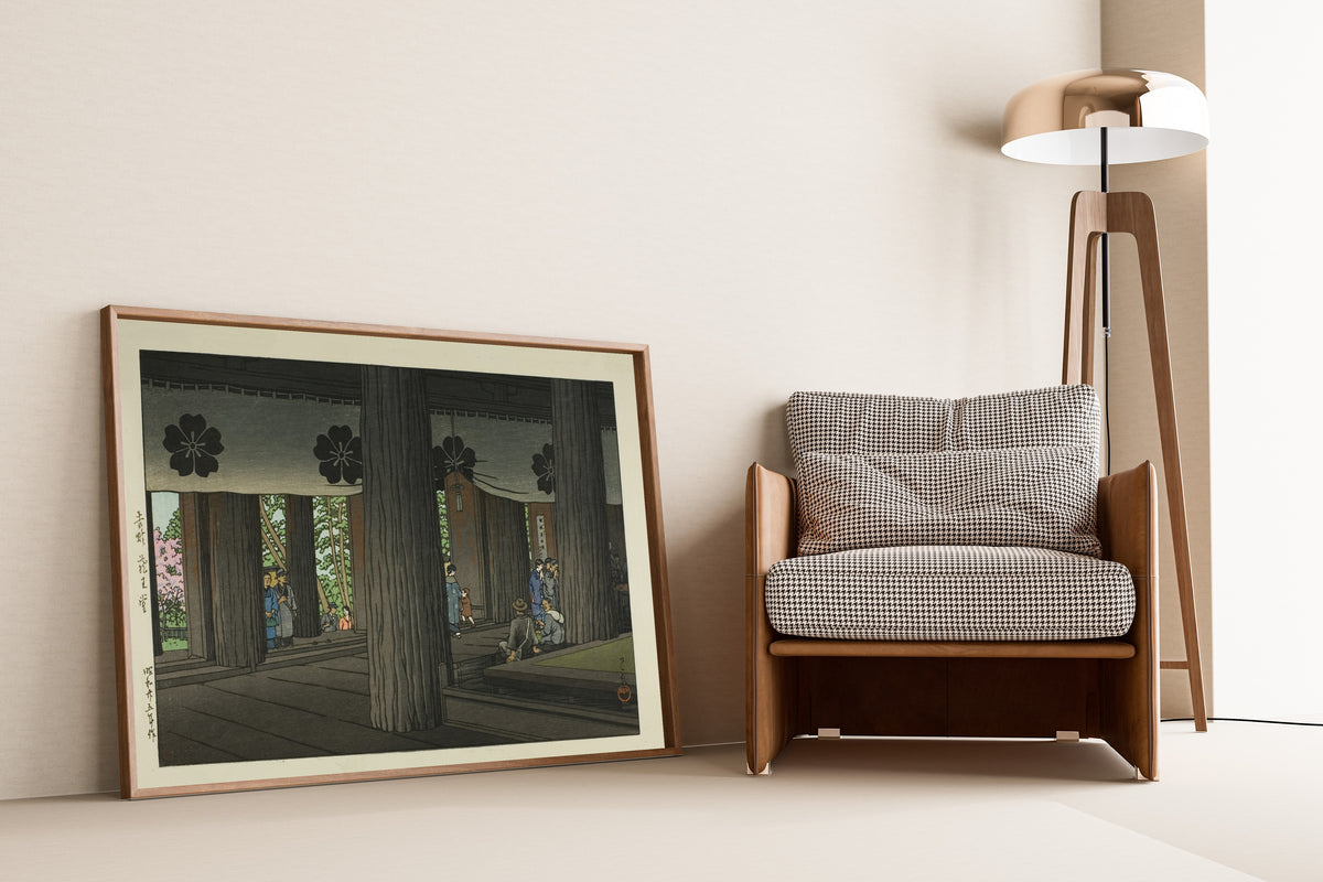 Framed art print of Zao Hall, Yoshino by Kawase Hasui, leaning against a wall beside an armchair and a floor lamp