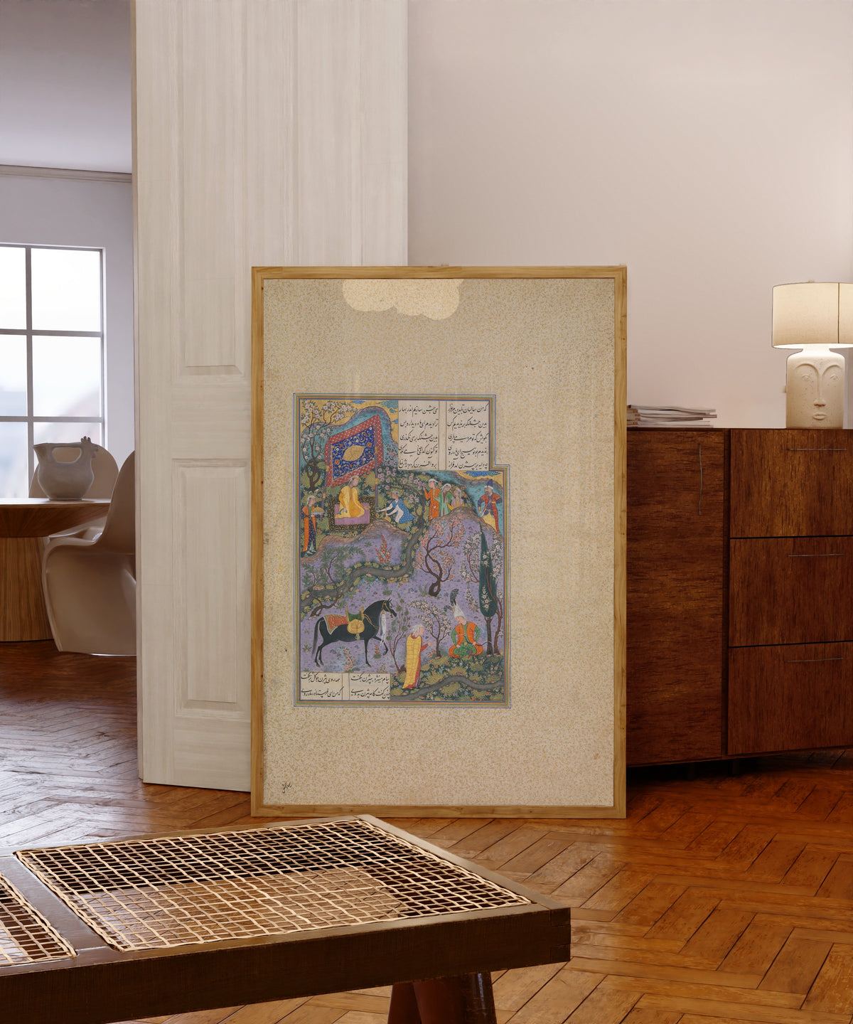 Framed art print of Shahnama of Shah Tahmasp: Bizhan Receives… by Abd al-Vahhab (attributed), in a light wood frame leaning in a warm room with a parquet floor