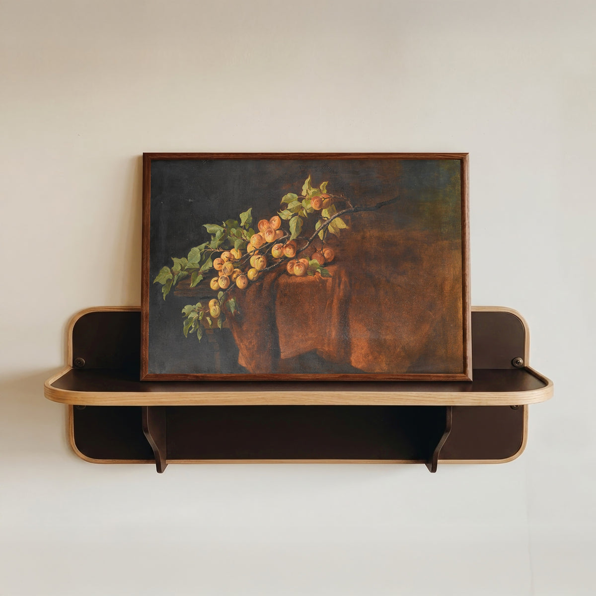 Framed art print of Apricot Branch by Adam Ludwig Kunz, in a dark wood frame resting on a wall shelf