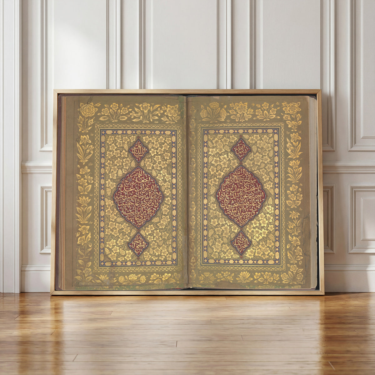 Framed art print of Book of Prayers: Illuminated Opening with Crimson Medallions by Ahmad Nairizi, in a light wood frame leaning against a panelled white wall