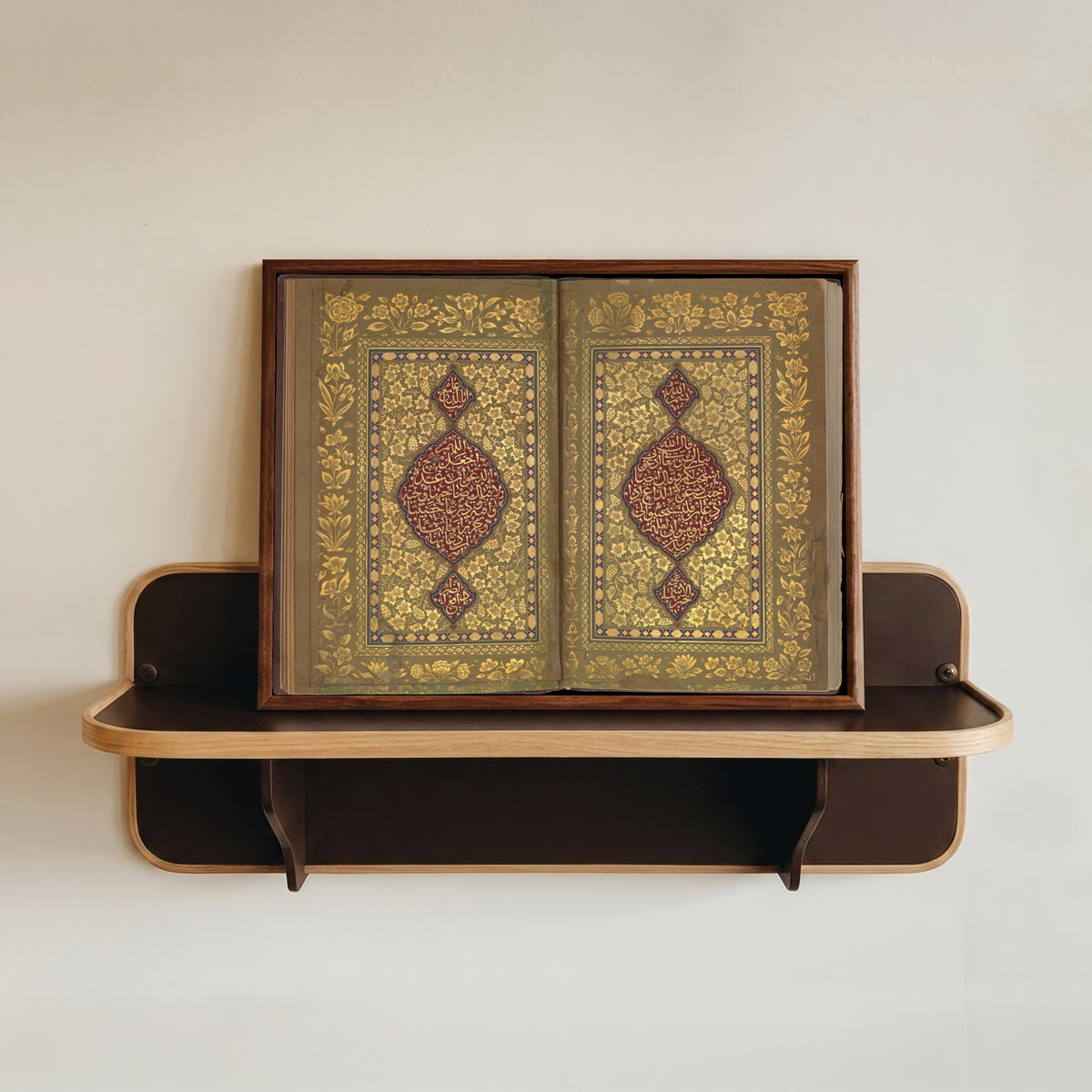 Framed art print of Book of Prayers: Illuminated Opening with Crimson Medallions by Ahmad Nairizi, in a dark wood frame resting on a wall shelf