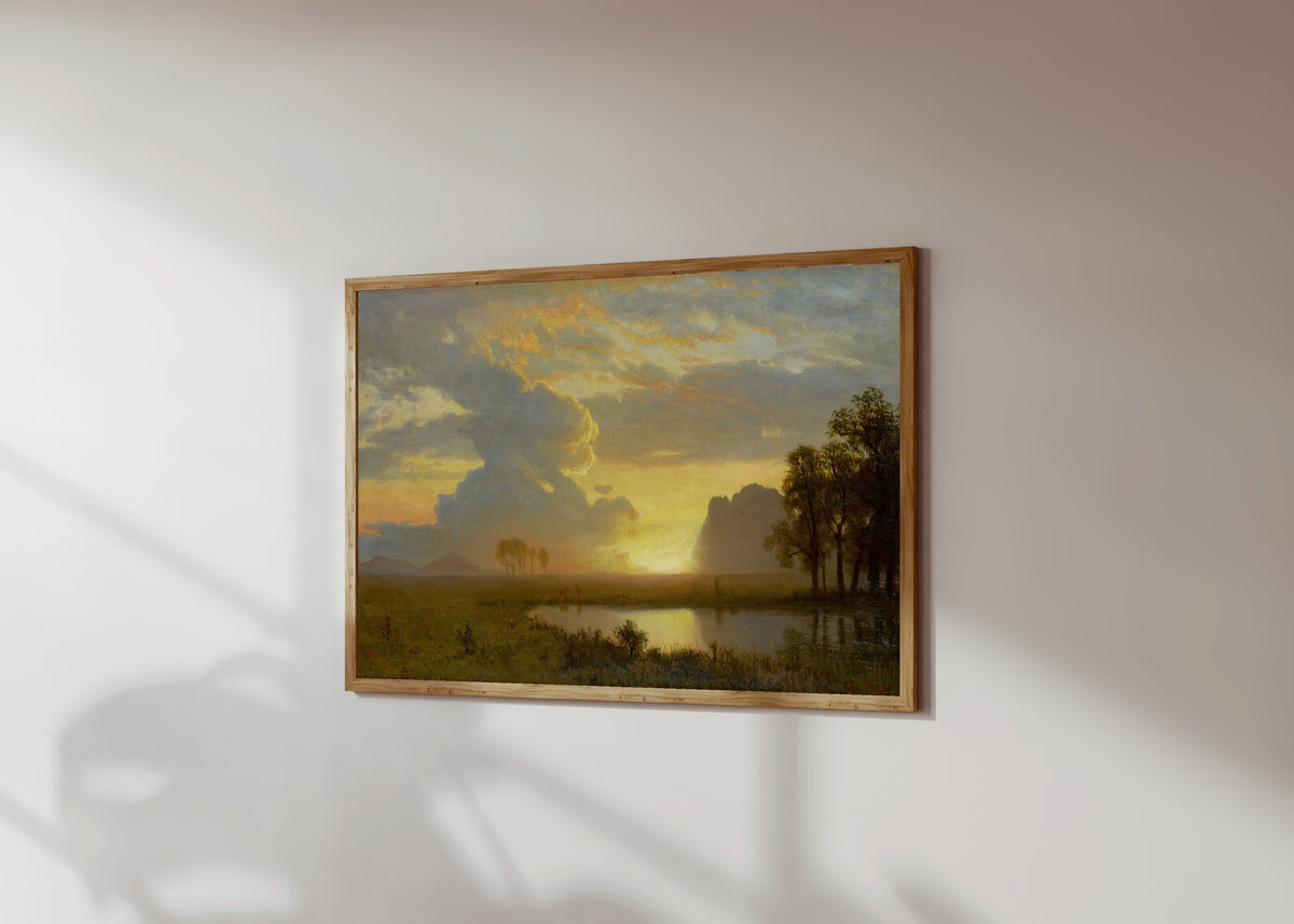 Framed art print of Estes Park, Colorado by Albert Bierstadt, in a light wood frame on a sunlit white wall, seen at a slight angle