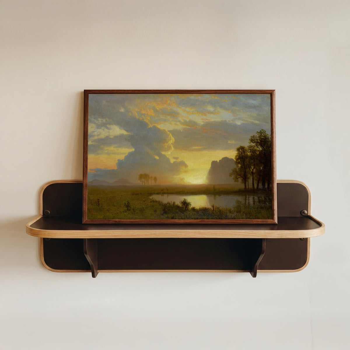 Framed art print of Estes Park, Colorado by Albert Bierstadt, in a dark wood frame resting on a wall shelf