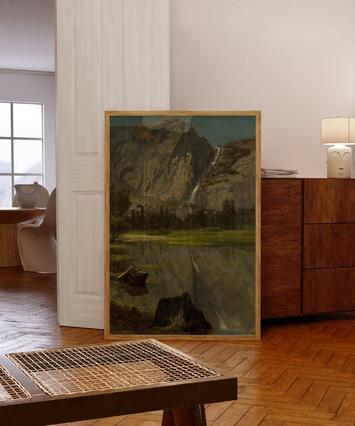Framed art print of Hetch Hetchy Falls, California by Albert Bierstadt, in a light wood frame leaning in a warm room with a parquet floor