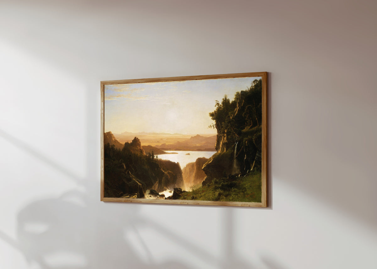 Framed art print of Island Lake by Albert Bierstadt, in a light wood frame on a sunlit white wall, seen at a slight angle