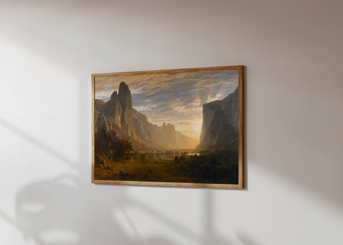 Framed art print of Looking Down Yosemite Valley by Albert Bierstadt, in a light wood frame on a sunlit white wall, seen at a slight angle