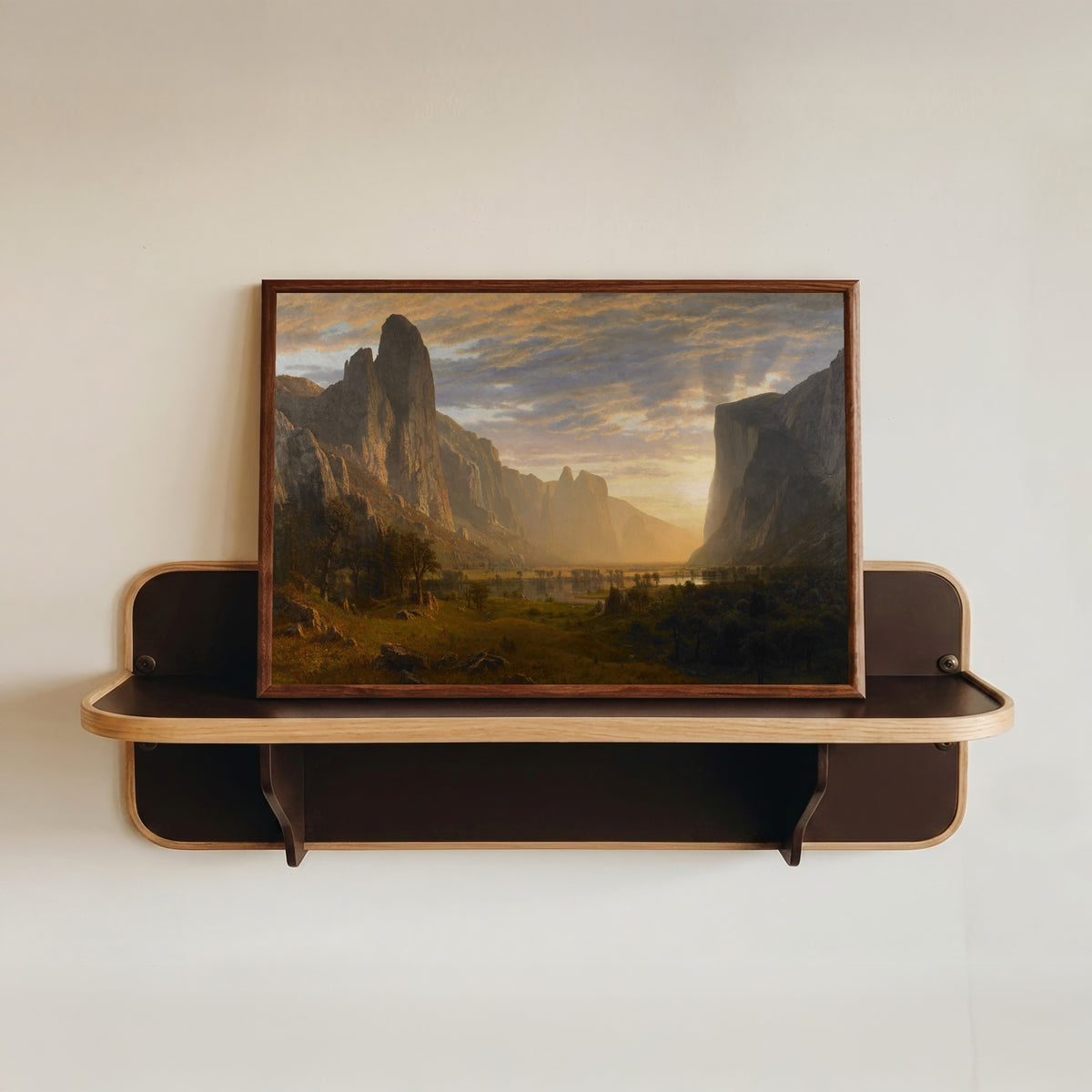 Framed art print of Looking Down Yosemite Valley by Albert Bierstadt, in a dark wood frame resting on a wall shelf