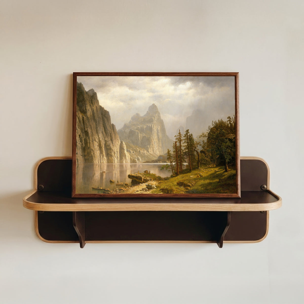 Framed art print of Merced River, Yosemite Valley by Albert Bierstadt, in a dark wood frame resting on a wall shelf
