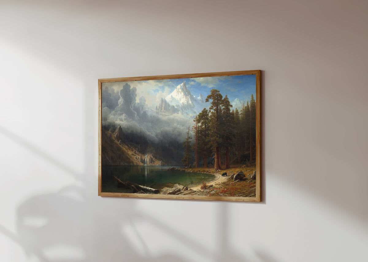 Framed art print of Mount Corcoran by Albert Bierstadt, in a light wood frame on a sunlit white wall, seen at a slight angle
