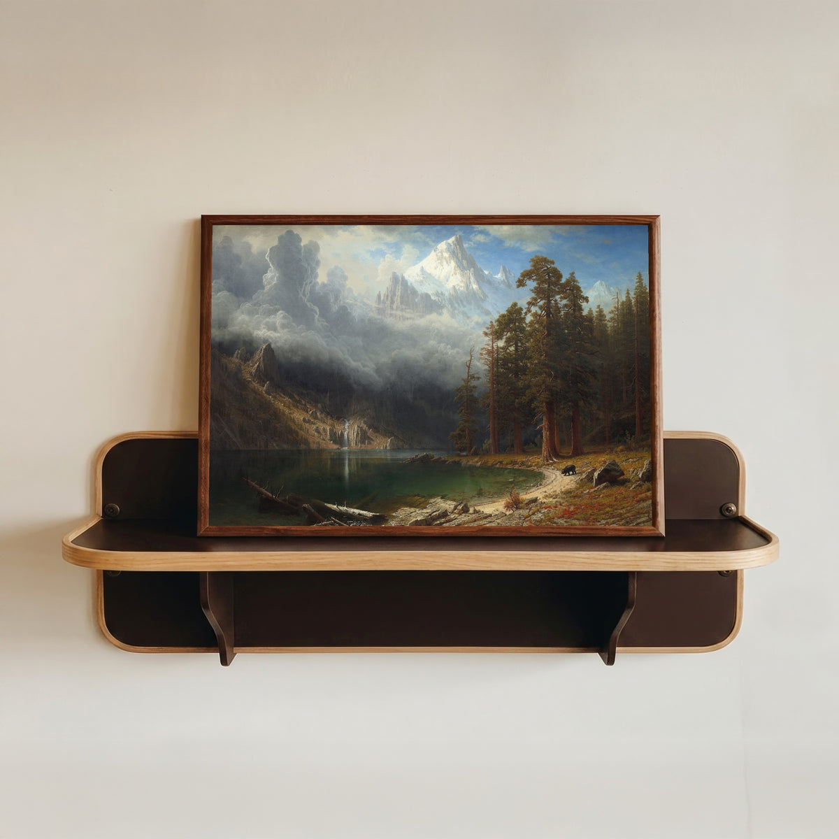 Framed art print of Mount Corcoran by Albert Bierstadt, in a dark wood frame resting on a wall shelf