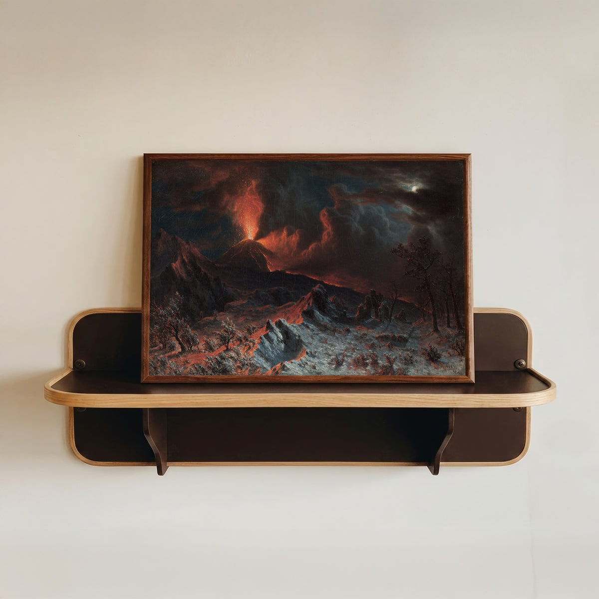 Framed art print of Mount Vesuvius at Midnight by Albert Bierstadt, in a dark wood frame resting on a wall shelf