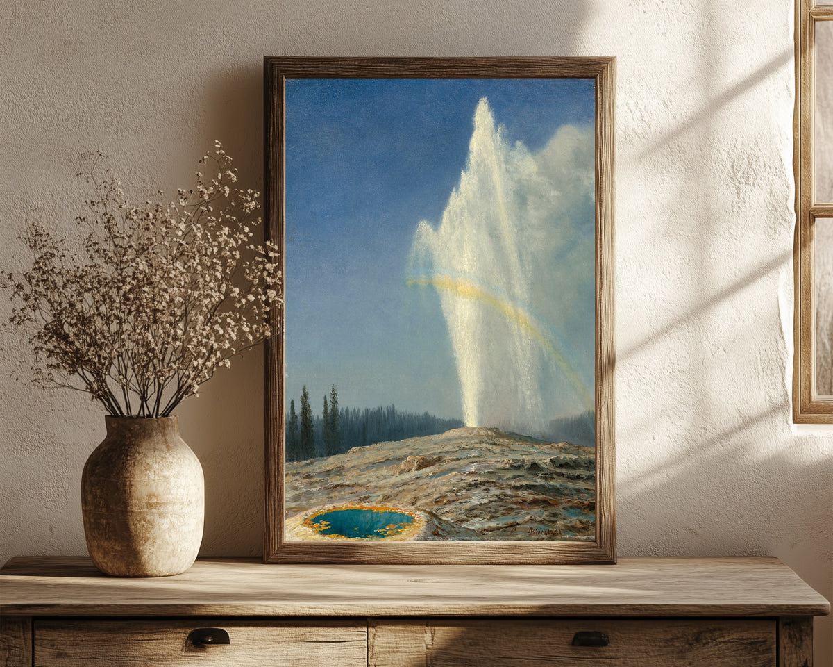 Framed art print of Old Faithful by Albert Bierstadt, in a dark wood frame leaning on a rustic console beside dried flowers