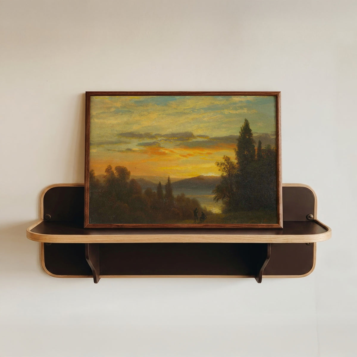 Framed art print of On the Hudson River Near Irvington by Albert Bierstadt, in a dark wood frame resting on a wall shelf