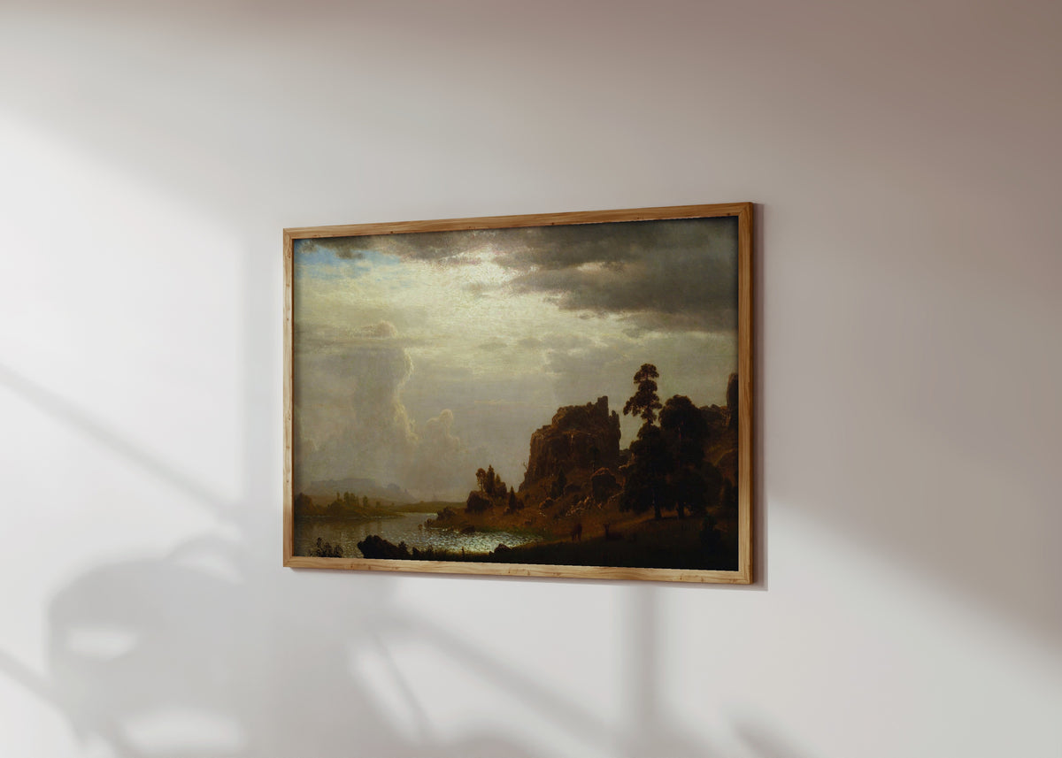 Framed art print of On the Sweetwater near the Devil's Gate by Albert Bierstadt, in a light wood frame on a sunlit white wall, seen at a slight angle