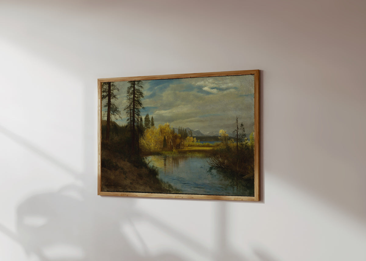 Framed art print of Outlet at Lake Tahoe by Albert Bierstadt, in a light wood frame on a sunlit white wall, seen at a slight angle