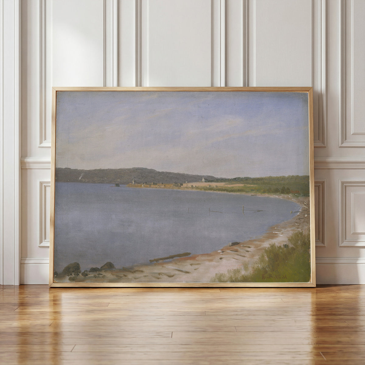 Framed art print of San Francisco Bay by Albert Bierstadt, in a light wood frame leaning against a panelled white wall