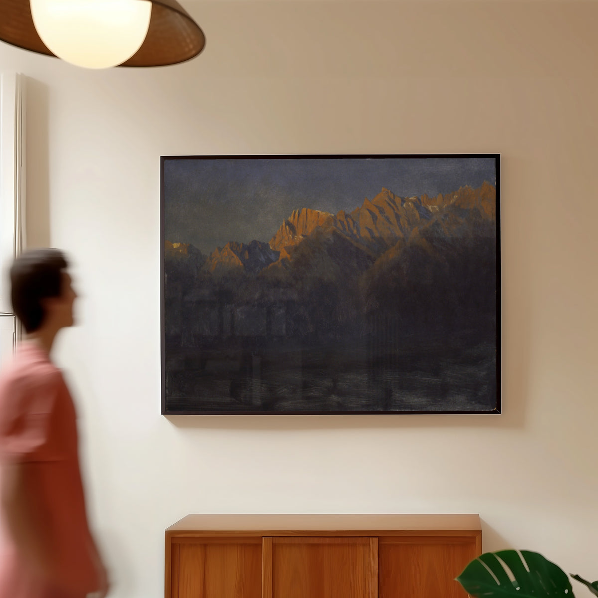 Framed art print of Sunrise in the Sierras by Albert Bierstadt, in a slim black frame on a warm wall in a sunlit room