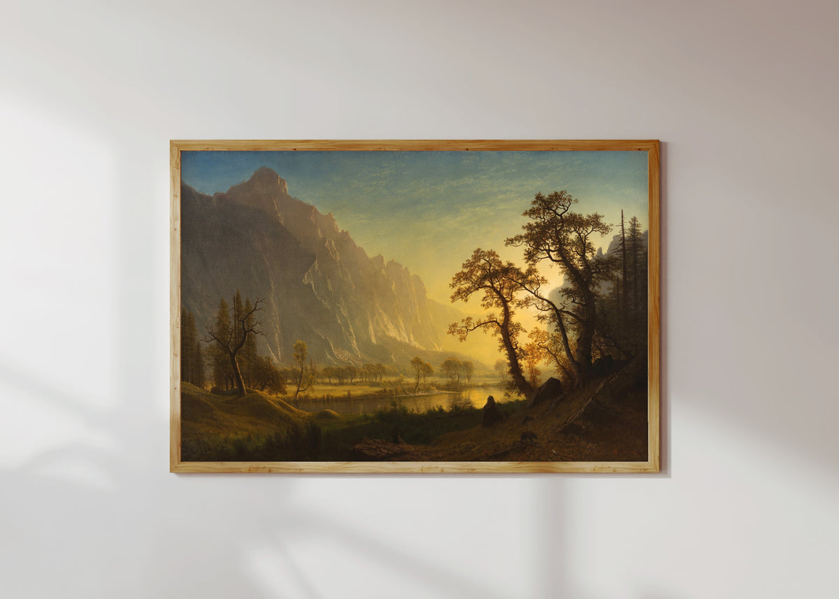 Framed art print of Sunrise, Yosemite Valley by Albert Bierstadt, in a light wood frame on a sunlit white wall