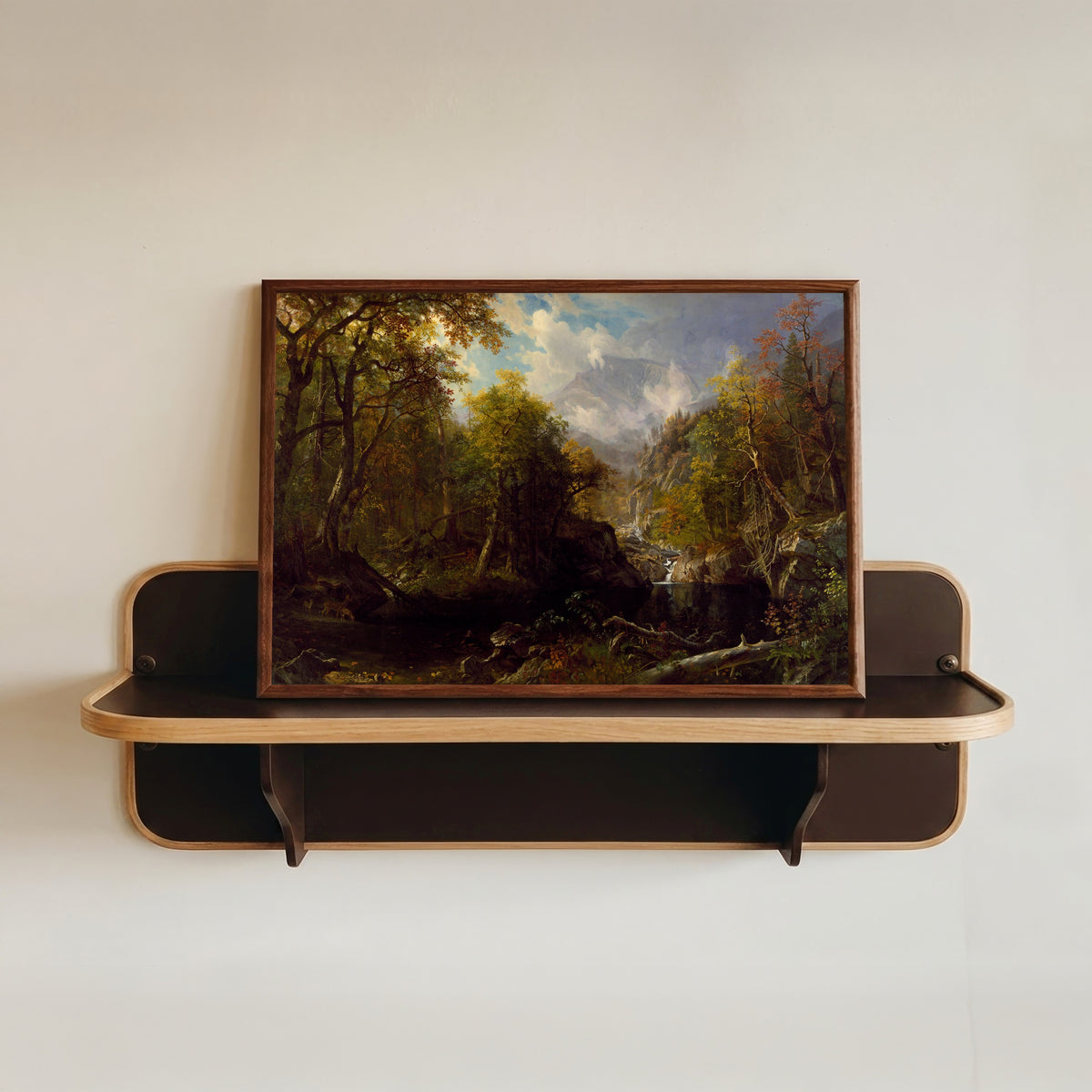 Framed art print of The Emerald Pool by Albert Bierstadt, in a dark wood frame resting on a wall shelf