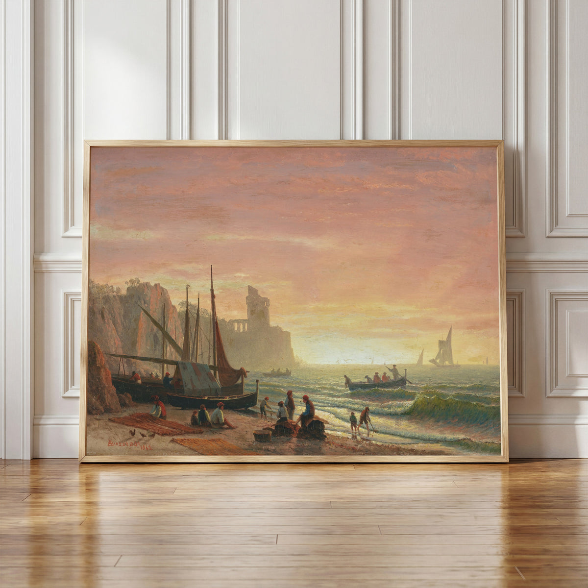 Framed art print of The Fishing Fleet by Albert Bierstadt, in a light wood frame leaning against a panelled white wall