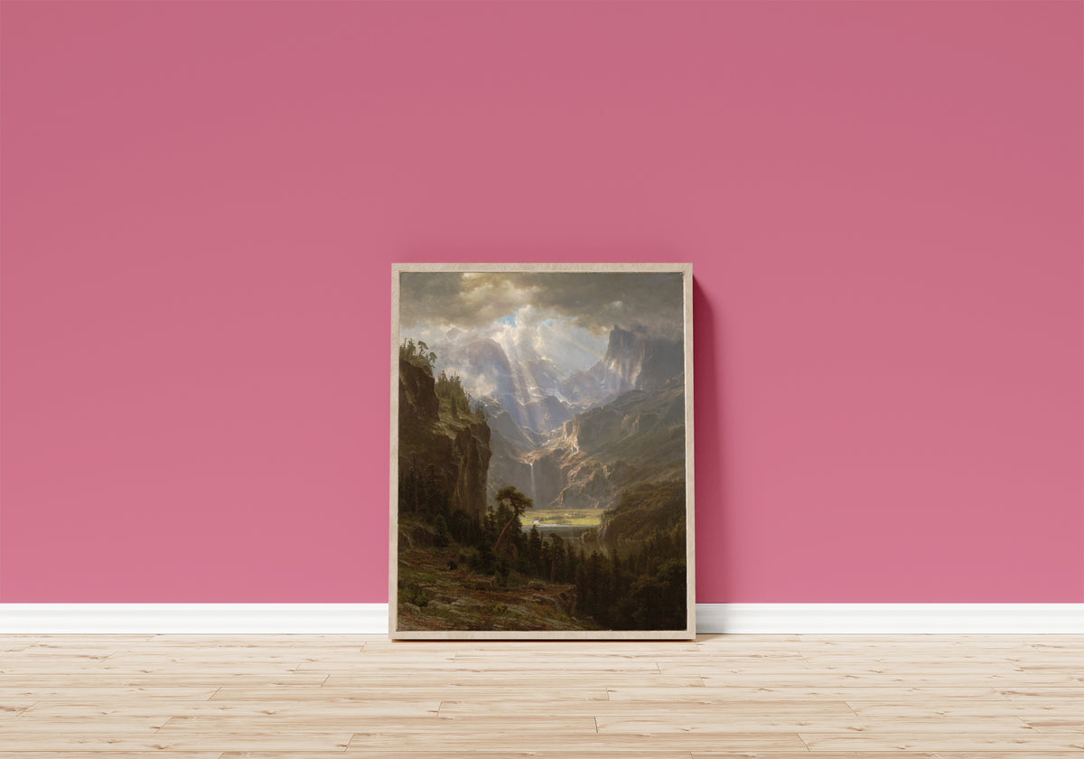 Framed art print of The Rocky Mountains, Lander's Peak (Alternate… by Albert Bierstadt, in a light wood frame leaning on a pink wall above a wooden floor