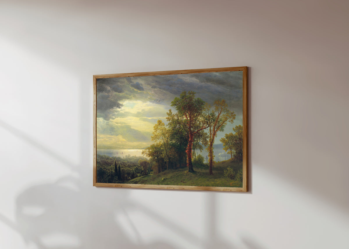 Framed art print of View on the Hudson by Albert Bierstadt, in a light wood frame on a sunlit white wall, seen at a slight angle