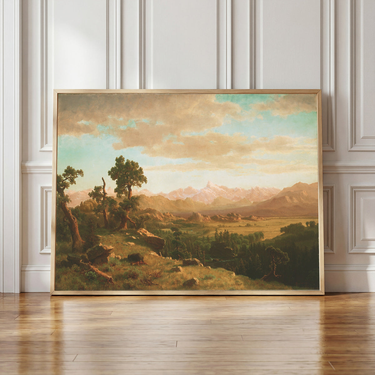 Framed art print of Wind River Country by Albert Bierstadt, in a light wood frame leaning against a panelled white wall