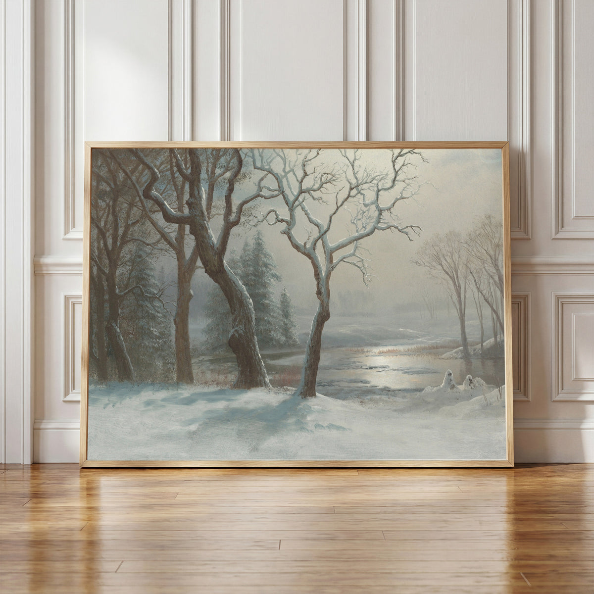 Framed art print of Winter in Yosemite by Albert Bierstadt, in a light wood frame leaning against a panelled white wall