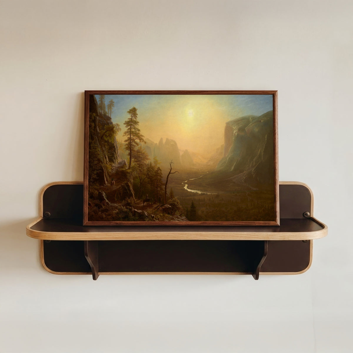 Framed art print of Yosemite Glacier Point Trail by Albert Bierstadt, in a dark wood frame resting on a wall shelf