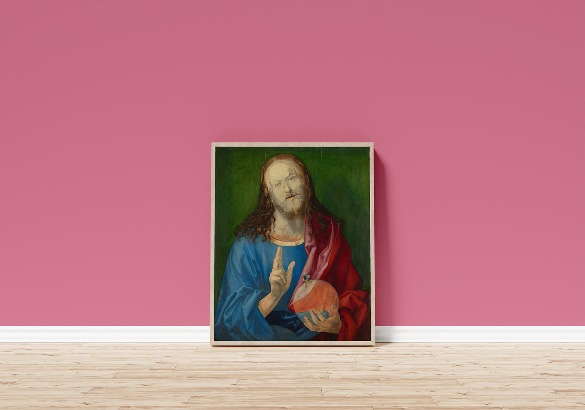 Framed art print of Salvator Mundi by Albrecht Dürer, in a light wood frame leaning on a pink wall above a wooden floor