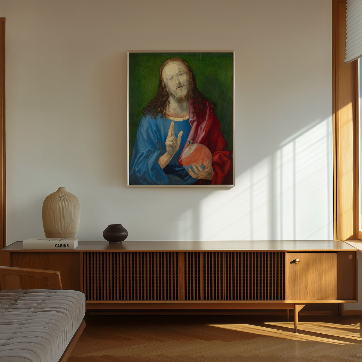 Framed art print of Salvator Mundi by Albrecht Dürer, in a thin light frame on a sunlit wall above a wooden sideboard